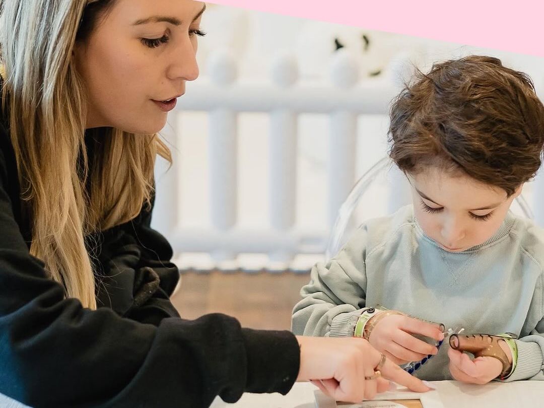 An animator doing a craft with a child at a kids corner