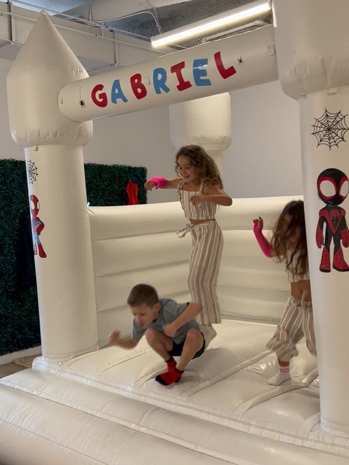 Kids jumping in a white bounce house